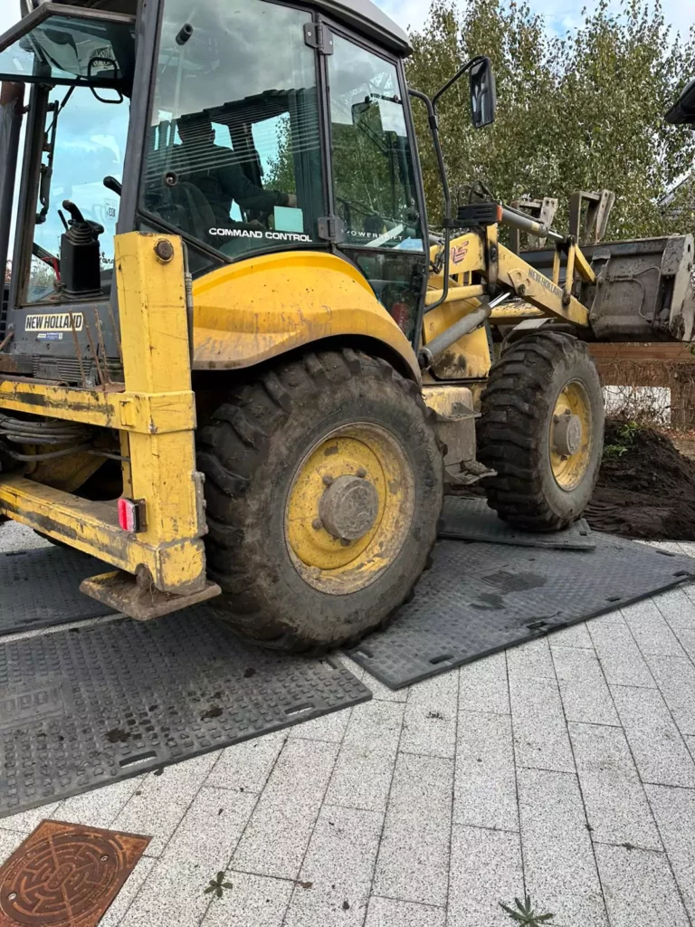Praca koparki na płytach drogowych w Szczecinie